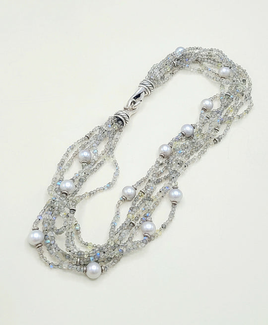 Multi-strand necklace with pearls and crystals on a light background