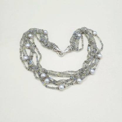 Multi-strand pearl and crystal necklace on a light background