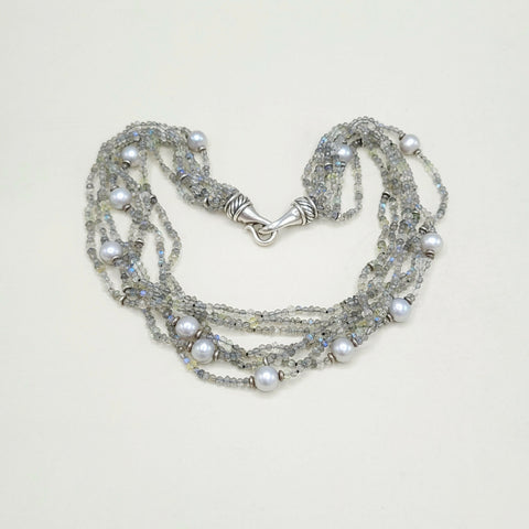 Multi-strand pearl and crystal necklace on a light background