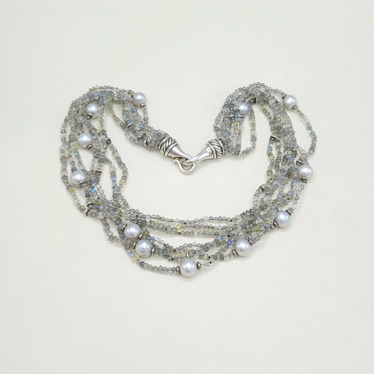 Multi-strand pearl and crystal necklace on a light background