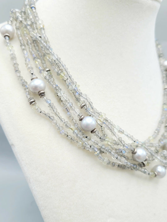 Multi-strand necklace with pearls and beads on a mannequin bust.
