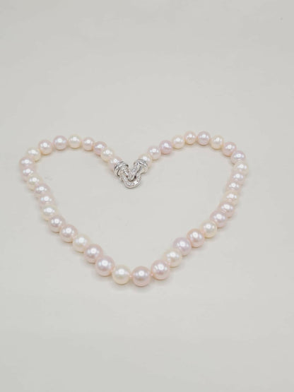 Pearl bracelet shaped like a heart on a light gray background
