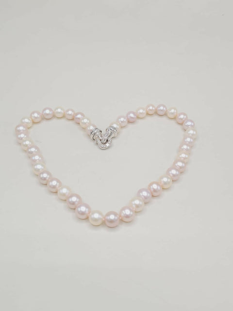 Pearl bracelet shaped like a heart on a light gray background