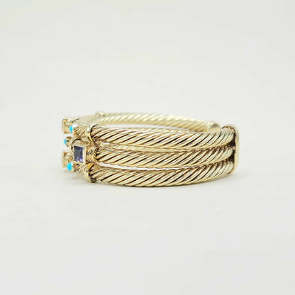Gold ring with a blue gemstone on a light gray background
