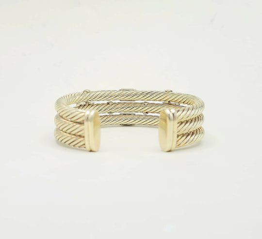 Gold bracelet on a light gray background