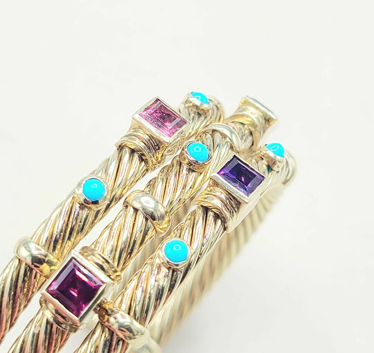 Gold bracelet with colorful gemstones on a white background