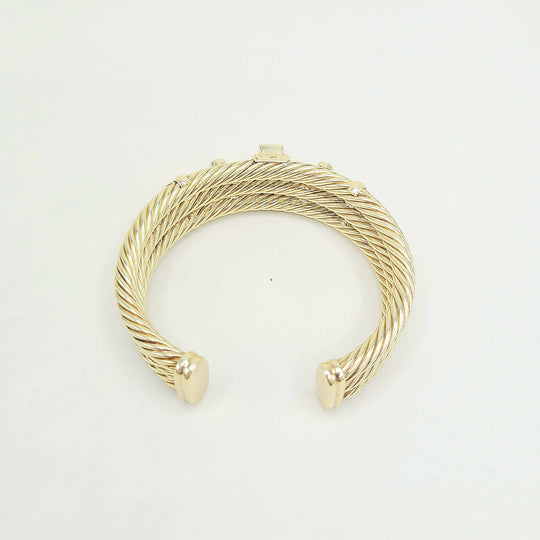 Gold bracelet on a light gray background