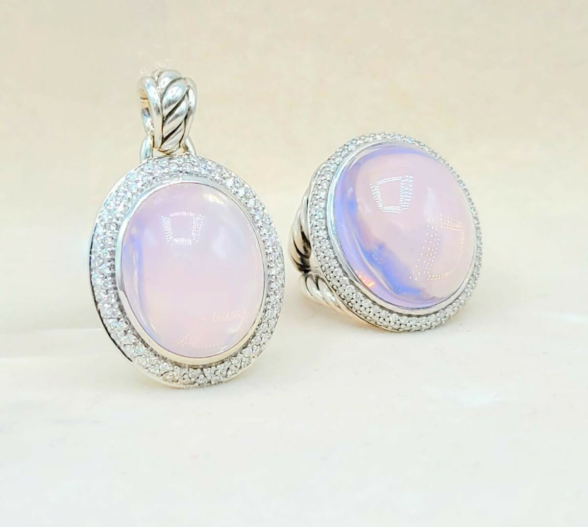 Pair of earrings with pink gemstones and silver settings on a light background