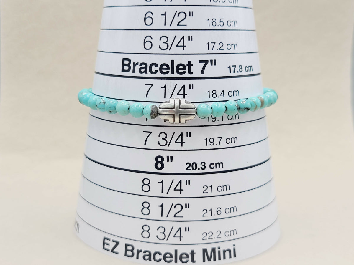 Turquoise beaded bracelet on a measuring cone with size markings.