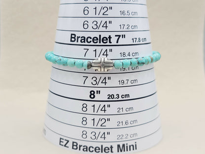 Turquoise beaded bracelet on a measuring cone with size markings.