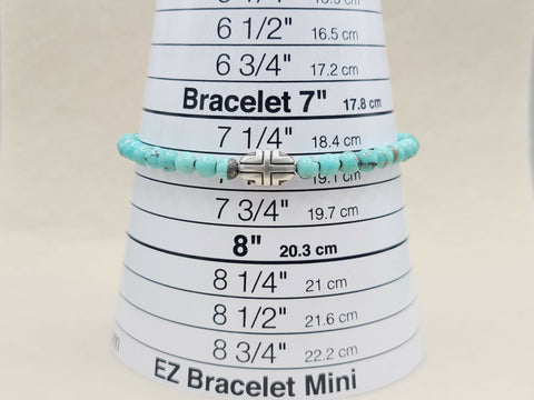 Turquoise beaded bracelet on a measuring cone with size markings.