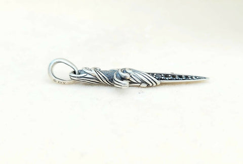 Silver pendant with intricate design on a white background