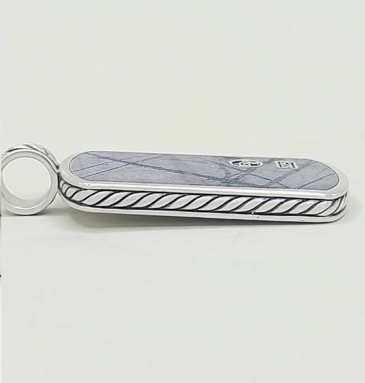 A silver-toned Gucci keychain or card holder featuring a blue-gray marble inlay with a subtle diamond pattern and a black twisted rope border, with the interlocking GG logo and a small square Gucci emblem on the top.